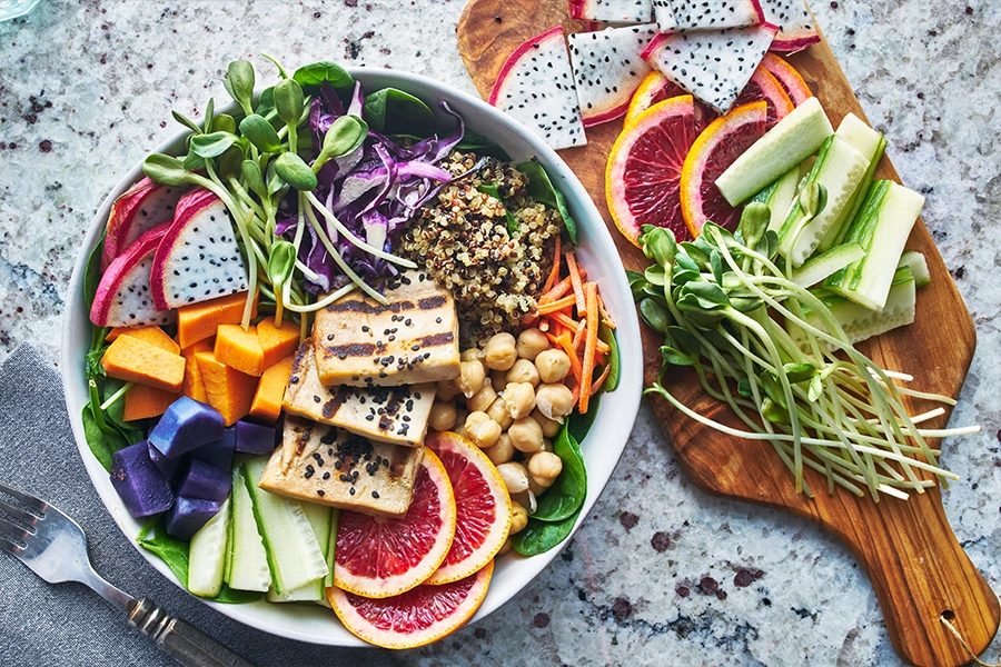 grilled tofu, vegetables, fruits, quinoa in bowl